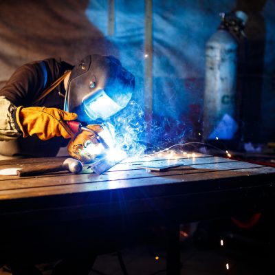 Worker cutting metal with plasma equipment. on plant